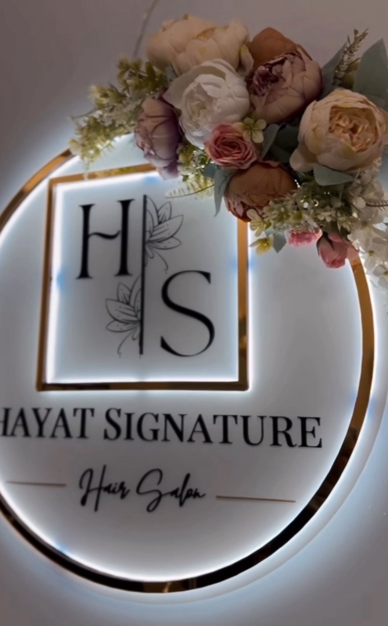 Hayat Signature branded salon logo displayed with flowers